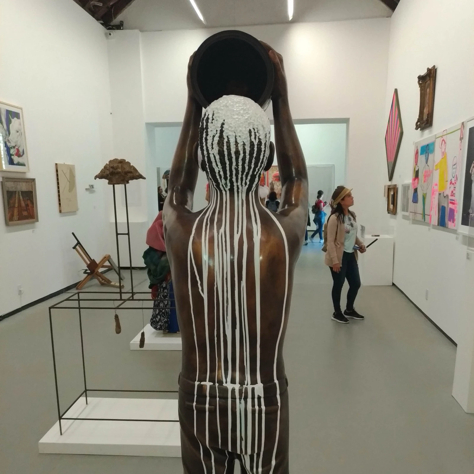 Exposição na EAV Parque Lage com uma escultura em primeiro plano.