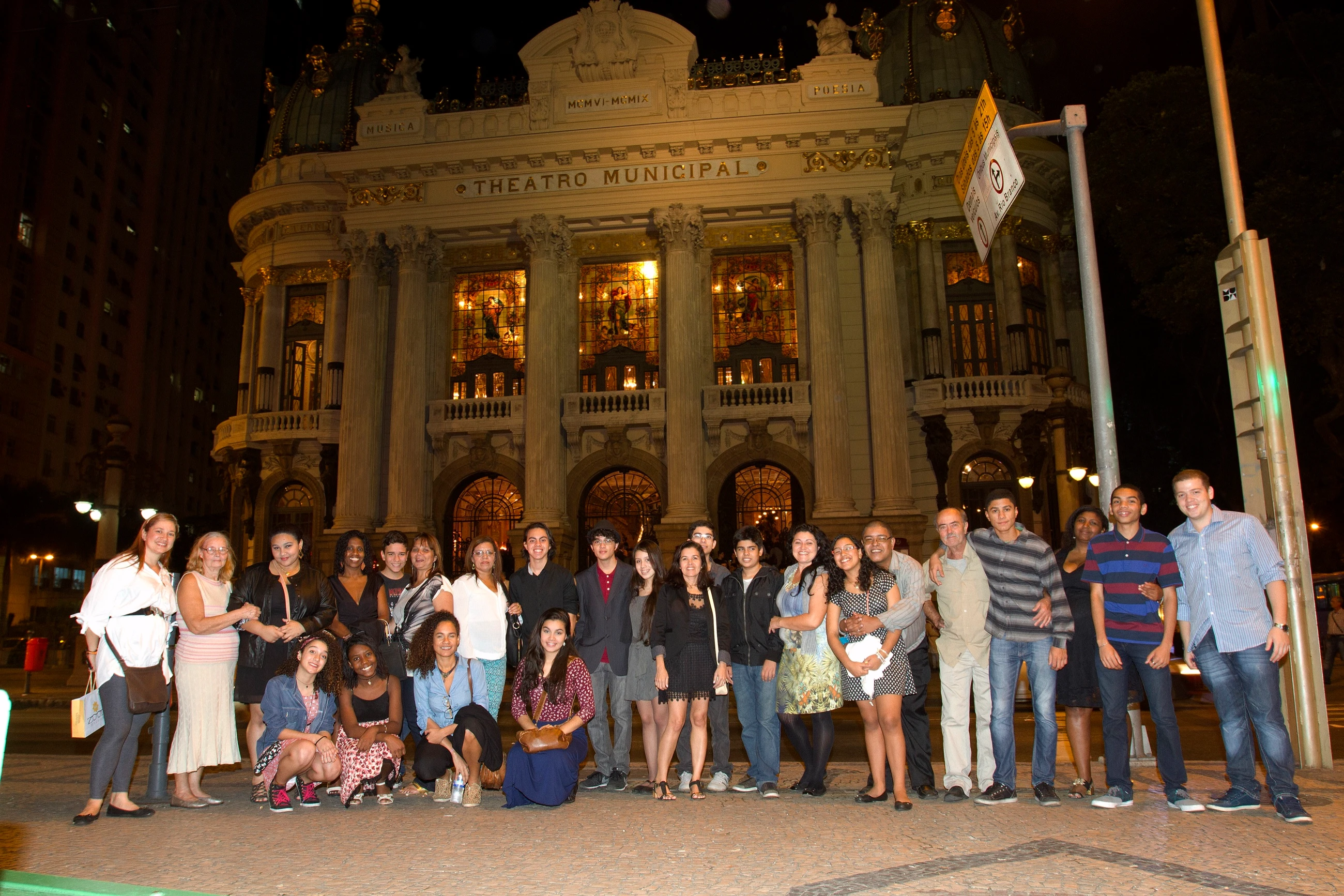 Público reunido na porta do Theatro Municipal do Rio, à noite.