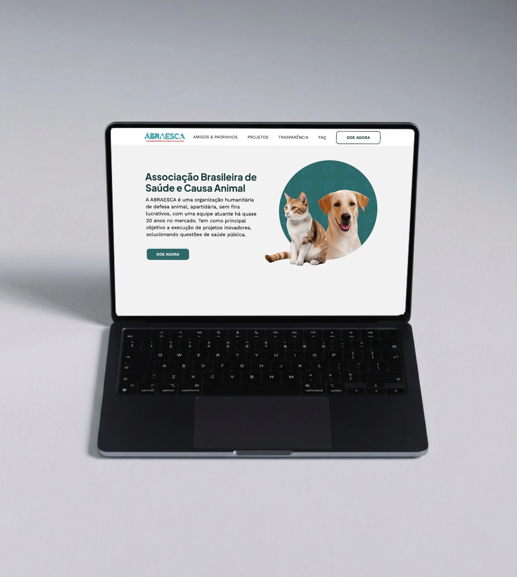 Site da ABRAESCA num laptop: menu com o botão Doe agora, título, texto de apresentação e a foto de um gato e um cachorro num círculo verde.